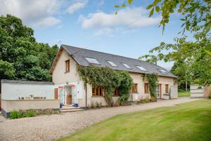 a white house with solar panels on the roof at Long Meadow Barn in Crediton