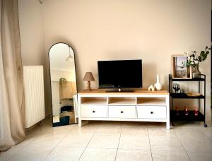 a living room with a television on a white dresser at Gemütliche Wohnung mit Balkon in Orestiada
