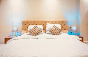 a large white bed with two pillows on it at Luxury, cozy, modern apartment in downtown Cairo in Cairo