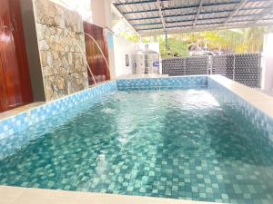 a swimming pool with blue tiles in a house at Sulong Inn - Private Pool Homestay in Kuantan, Pantai Sepat in Kuantan