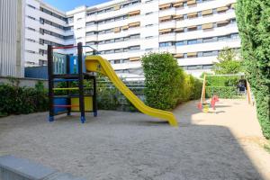 ein Spielplatz mit Rutsche vor einem Gebäude in der Unterkunft Moderno Apartamento TEMPORAL Familiar con Terraza SOD1 in Madrid
