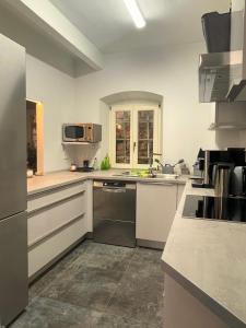 a large kitchen with white cabinets and appliances at Huus Bellevue in Gleisweiler