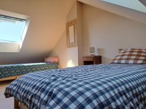 Un dormitorio con una cama azul y blanca y una ventana. en Mazy, en Le Croisic