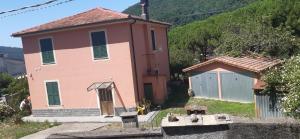 a small pink house with a gate in front of it at La casa dei Giomi in Deiva Marina
