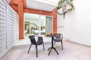 a patio with two chairs and a table with fruit on it at Notus Chania Crete in Chania