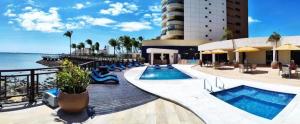 a resort with two swimming pools and a building at Flat no Iate Plaza Hotel in Fortaleza