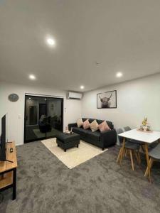 un salon avec un canapé et une table dans l'établissement Central City Convenience At The Salt District, à Christchurch