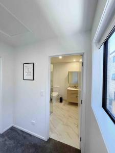 une salle de bain blanche avec toilettes et lavabo dans l'établissement Central City Convenience At The Salt District, à Christchurch