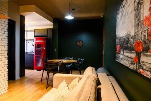 een woonkamer met een bank en een rode telefooncel bij Luix Londrina Flat Hotel , 707, QS completo in Londrina