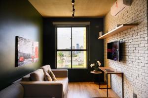 a living room with a couch and a large window at Luix Londrina Flat Hotel , 707, QS completo in Londrina