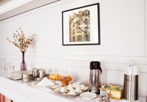 a white counter with a shelf with cups and dishes at Biazi Plaza Hotel Bauru in Bauru