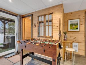 Private beach with SPA on the lake I Plage Sucrée في Saint-Rémi-dʼAmherst: غرفة مع طاولة فوت بول أمام الحائط