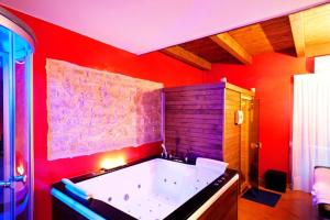 a large bath tub in a room with red at Perbacco in SantʼAngelo Limosano