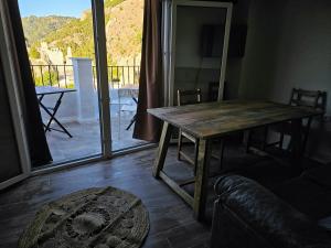 a wooden table in a living room with a balcony at La Mocha Casa Rural - La Casa de María in La Iruela