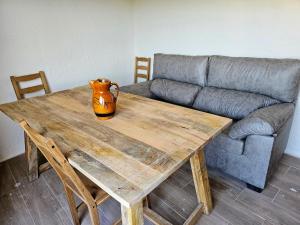 a vase sitting on a wooden table with a couch at La Mocha Casa Rural - La Casa de María in La Iruela +31 photos