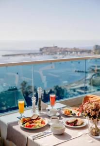 a table with plates of food and a view of the ocean at TC BiG APARTMENTS in Budva