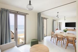a living room with a dining room table with a view of the ocean at Hôtel La Suite in Biarritz