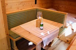 a wooden table with a bottle and a wine glass at Charmantes Tiny House am Rande der Lüneburger Heide in Kirchlinteln +3 photos