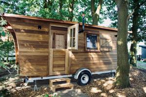 a wooden tiny house parked next to a tree at Charmantes Tiny House am Rande der Lüneburger Heide in Kirchlinteln