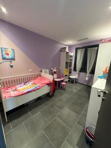 ein Schlafzimmer mit einem Bett mit einer violetten Decke in der Unterkunft Maison Isle sur la sorgue in LʼIsle-sur-la-Sorgue + 4 Fotos