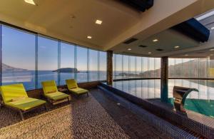 a room with two yellow chairs and a swimming pool at TC BiG APARTMENTS in Budva