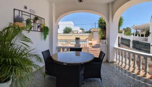 a patio with a table and chairs on a balcony at Chalet independiente con piscina in Partida de La Cañada