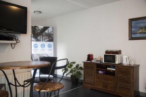 a room with a table and chairs and a tv at Smartappart Cherbourg (la rose des vents) in Cherbourg en Cotentin