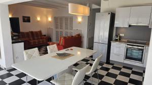 a kitchen and living room with a white table and chairs at Playa del Sol-Casa Playa in Denia