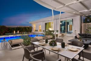 a dining room with a table and chairs and a pool at Villa Gaia Green-Adults only in Kolimbia