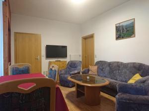 a living room with a couch and chairs and a table at Ferienhaus Schrammsteinblick in Schöna