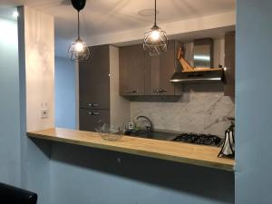 a kitchen with three pendant lights and a counter top at Vila Peña Private Apartment with Shared Pool & Gardens in Cubelles