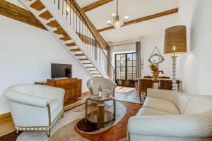 a living room with white furniture and a staircase at Château Hermitage de Combas in Servian