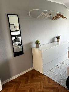 een witte dressoir in een kamer met een spiegel bij The Climb in Koblenz +7 foto's