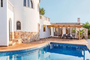 a house with a swimming pool and a patio at Chalet Es Llossar in Cala en Blanes