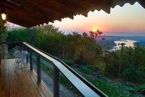 a balcony with a view of the ocean at sunset at Minas Em Marambaia in Rio de Janeiro