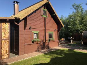 a small red house with two windows and a yard at Ferienhaus Haus am See in Sternberg