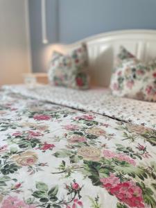 a bed with a floral comforter and pillows on it at NEU! OASIS - FeWo am Harz, hochwertig Kernsaniert, 83 qm, EG in Nordhausen