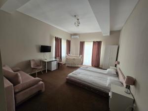 a hotel room with a bed and a couch at B&B Andero Deva in Deva