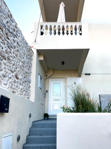 a staircase leading up to a white building with a door at Odysseus Boutique Apartment in Ermioni