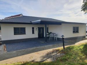 een wit huis met een tafel ervoor bij ADAM Gästehaus in Sülzetal