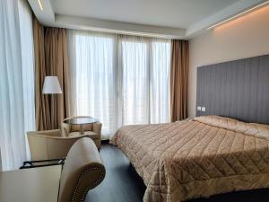una stanza d'albergo con un letto e una sedia di Hotel Datini a Prato