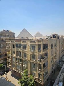 开罗The Home Boutique Hotel Pyramids Inn的公寓大楼的顶部设有金字塔