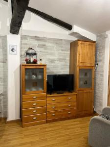 a living room with a television and a wooden dresser at La casita de mi abuela in Santo Domingo de la Calzada