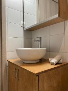 a white bowl sink on a wooden counter in a bathroom at Odysseus Boutique Apartment in Ermioni +19 photos