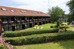a building with a garden and chairs in front of it at Hotel Sonnenhof in Bad Birnbach