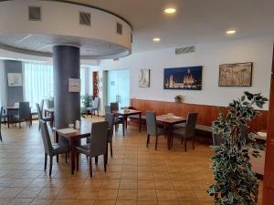 una sala da pranzo con tavoli e sedie in un ristorante di Hotel Datini a Prato