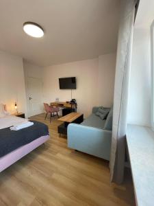 a bedroom with a bed and a desk with a television at Terminal Family Airport in Poznań