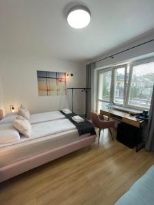 a bedroom with a bed and a desk and a window at Terminal Family Airport in Poznań