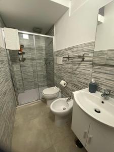 a bathroom with a toilet and a shower and a sink at Dimora Scarpa in Bari