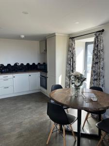 a kitchen and dining room with a table and chairs at The Barn Springmount Accommodation in Dromara